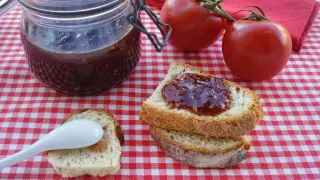 Tarro de mermelada de tomate casera, tomates frescos y tostadas con mermelada. ¡Un manjar para disfrutar!