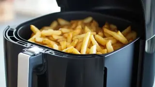 Patatas fritas doradas y crujientes listas para disfrutar, recién salidas de la freidora de aire.