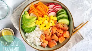 Un colorido poke bowl hawaiano con salmón, arroz, aguacate, mango, zanahoria, rábano y pepino.