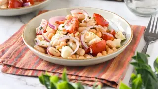 Ensalada de legumbres fresca con garbanzos, judías blancas, tomate y cebolla morada.